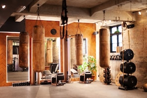 A gym with punching bags, weightlifting equipment, and a mirror. - Bryggen Guldsmeden (Copenhagen)