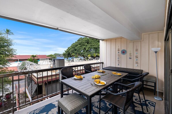 A balcony with a table and chairs, a view of the city, and a decorative wall.