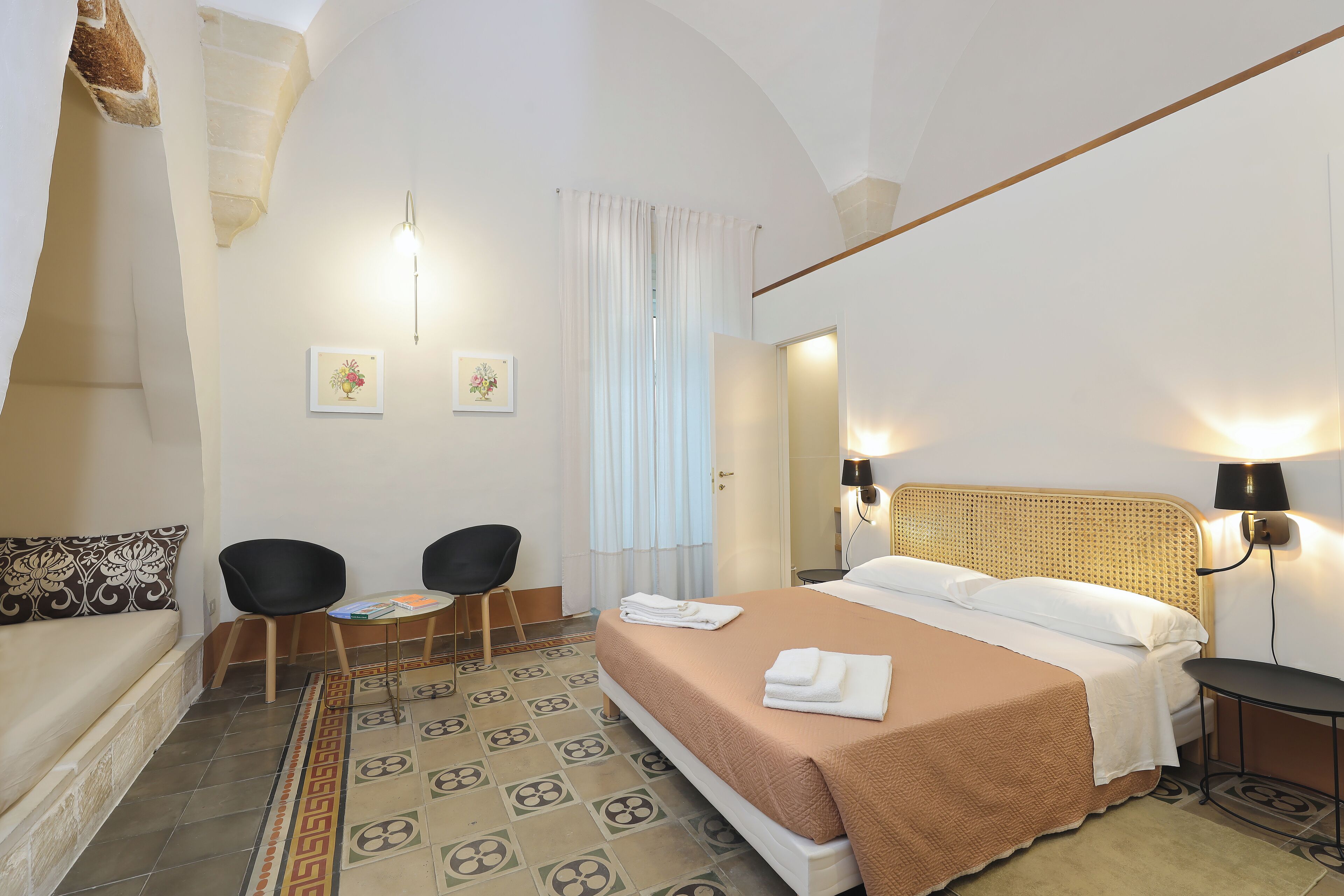 Ein Hotelzimmer mit einem Bett, zwei Sesseln, einem kleinen Tisch, einer Couch und einem dekorativen Teppich.