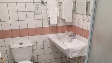 Een badkamer met toilet, wastafel en douche.
