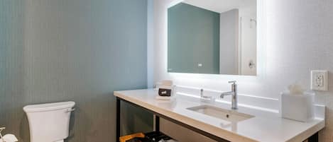Ein modernes Badezimmer mit Toilette, Waschbecken und Spiegel.