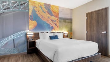 A bedroom with a bed, nightstands, a wooden door, and a wall with a large abstract painting.
