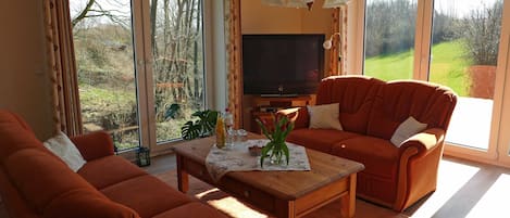 Un salon avec un canapé, une table basse et un téléviseur.