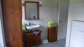 Un baño con lavabo, espejo y armarios de madera.