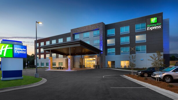 Ein Holiday Inn Express Hotel mit modernem Design, inklusive überdachter Eingangspartie und zahlreichen Fenstern.