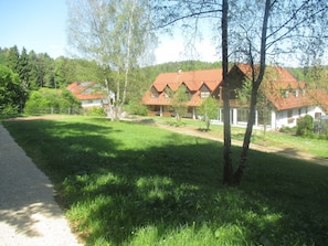 A residential area with multiple houses, a paved path, and a grassy field.