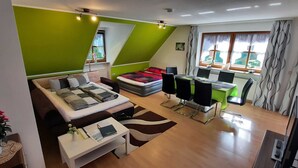 Una sala de estar moderna con un sofá, una mesa de comedor y un televisor.