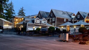 Een rij huizen met garages, een verharde oprit en een brievenbus.
