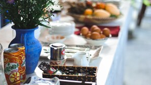 A buffet table with various food items and a blue vase with flowers.