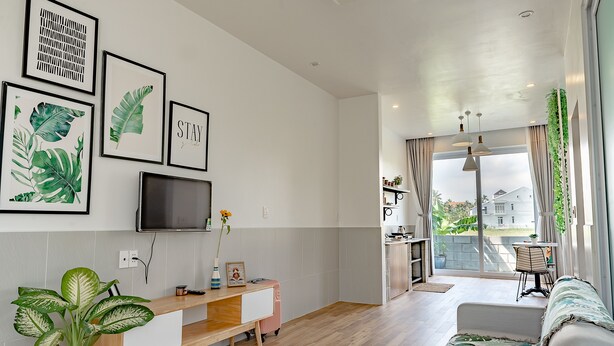 A modern living room with a TV, artwork, and a sofa.