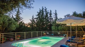 Une piscine extérieure avec des chaises longues et une pergola.
