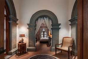 A hallway with a bed, a chair, and a lamp. - Hacienda Santo Cristo Hotel & Spa - Adults Only (Atlixco)