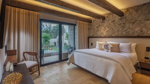Un dormitorio con una cama grande, techo de madera, pared de piedra y vistas al exterior.