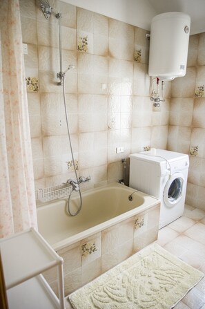 Tina con regadera, secadora de cabello, bidet, toallas 