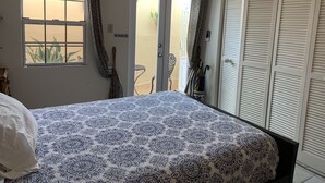 A bedroom with a bed, a window, a door, and a view of the outside. - STUDIO  Walking distance to beach. (Isla Verde)