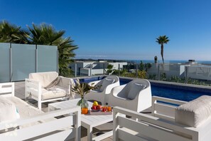 A rooftop terrace with white furniture, a pool, and a view of the sea. - Villa NEVIS by Abahana Villas (Benitachell)