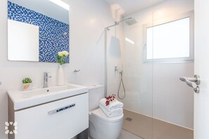 A modern bathroom with a white sink, a glass shower enclosure, and a toilet. - Villa NEVIS by Abahana Villas (Benitachell)