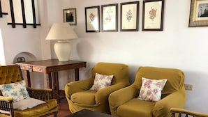 Ein Wohnzimmer mit einer Couch, Sesseln, einem Couchtisch und einer Lampe.