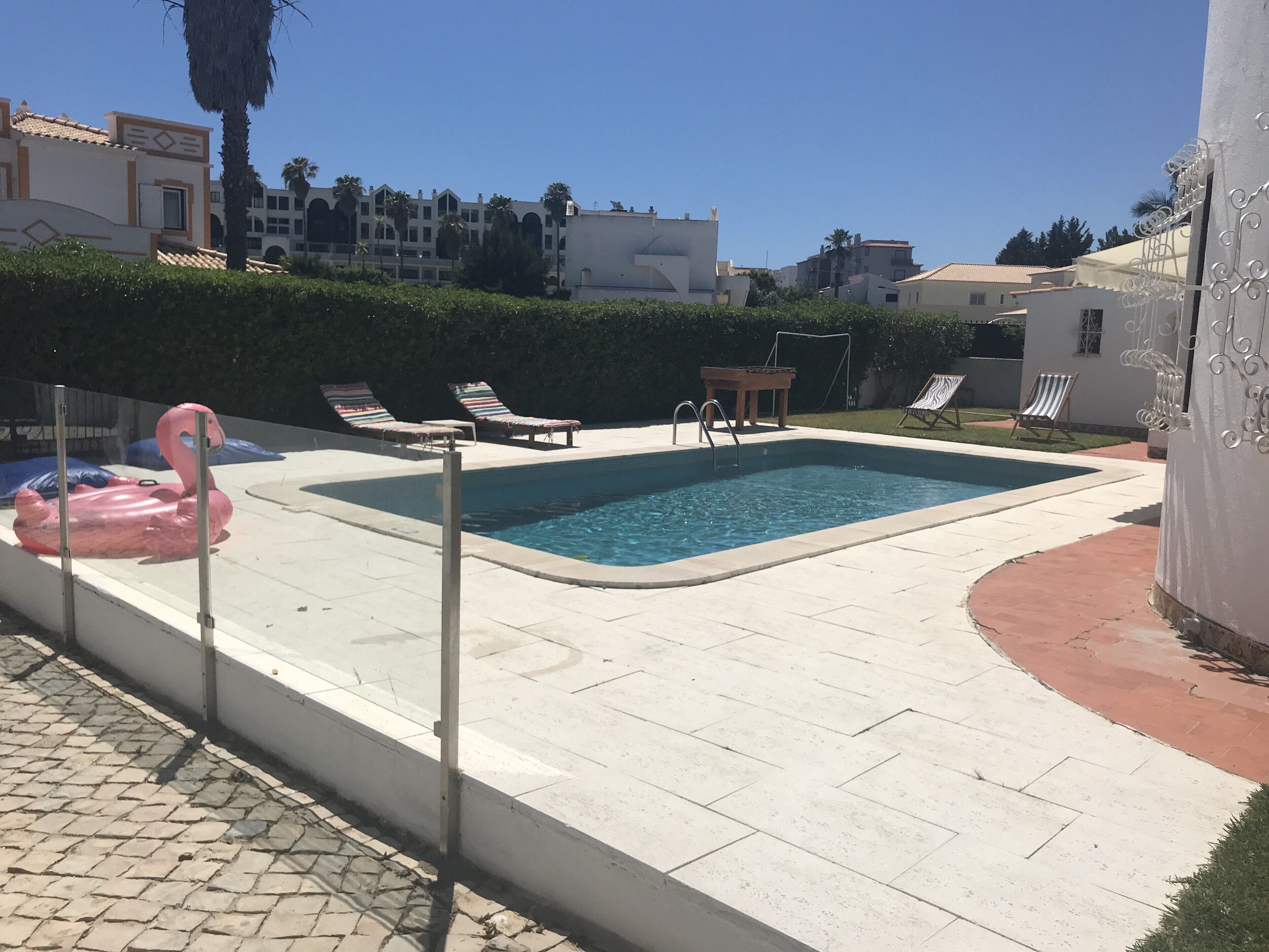 A swimming pool with lounge chairs and a flamingo float.