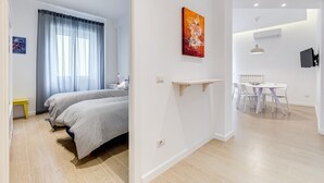 Ein modernes Schlafzimmer mit einem Bett, einem Nachttisch und einem Fenster mit Vorhängen.