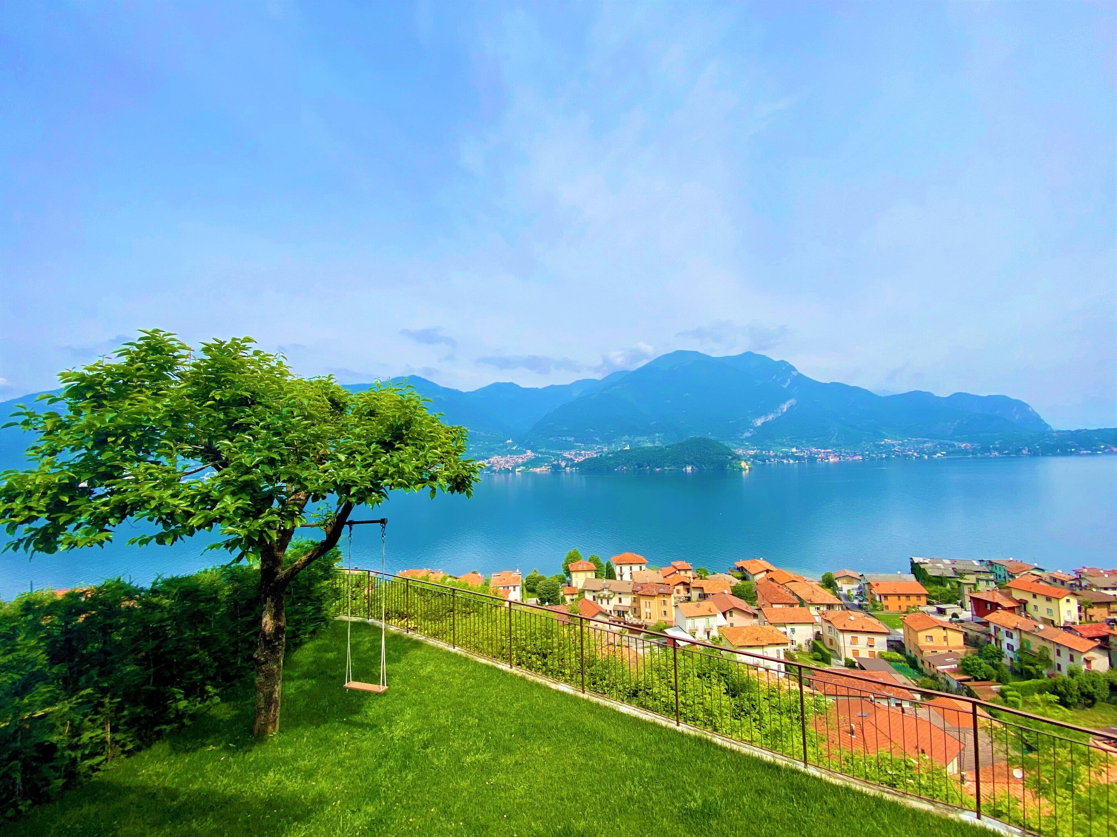 Ein malerischer Blick auf einen See, im Vordergrund eine Stadt und im Hintergrund Berge.