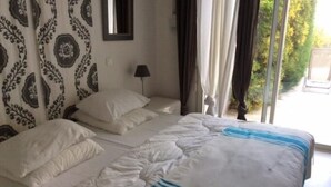 A bed with white bedding and a blue stripe, a bedside lamp, and a window with curtains. - House in a residence for 8 person (s) - Lumio (St Ambroggio Lumio)