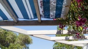 An outdoor patio with a table and chairs, a covered seating area, and a bicycle in the background. - House in a residence for 8 person (s) - Lumio (St Ambroggio Lumio)