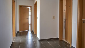 A hallway with wooden doors, each marked with a number. - Apartment Noerdliches Muensterland (Hopsten)