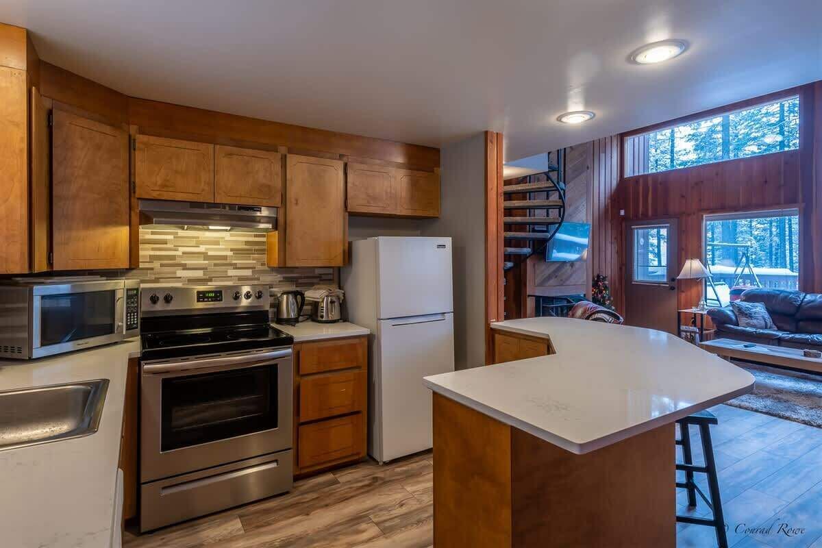 A modern kitchen with wooden cabinets, stainless steel appliances, and a large island.