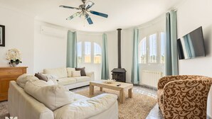 A living room with a sofa, armchair, coffee table, and a fireplace. - Villa MACKAY by Abahana Villas (Calpe)