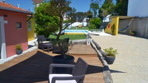 A patio with wicker furniture, a small pool, and a hammock.