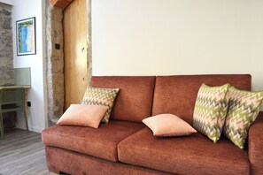 A brown sofa with patterned cushions, a wooden accent wall, a framed map, and a green chair. - Villa Santa Bárbara (Vila Nova de Gaia)