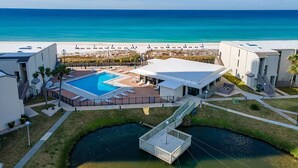 Un complex turístic amb piscina, terrassa coberta i vistes a la platja i l'oceà.