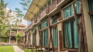 A hotel with multiple floors, large windows, and a covered walkway. - Gunung An Retreat (Ubud)