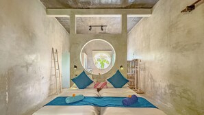 A room with a bed, a circular mirror, and a view of the outside. - Gunung An Retreat (Ubud)