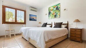 A bedroom with two beds, a chair, a nightstand, and a window with a view. - Villa MIMOSA by Abahana Villas (Benitachell)