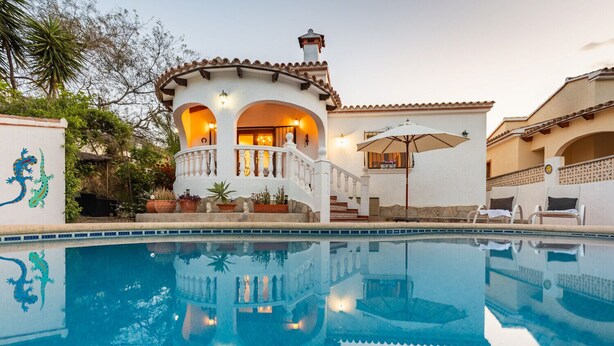 A poolside view of a building with a white facade, terracotta roof tiles, and a balcony with a railing. - Villa MIMOSA by Abahana Villas (Benitachell)