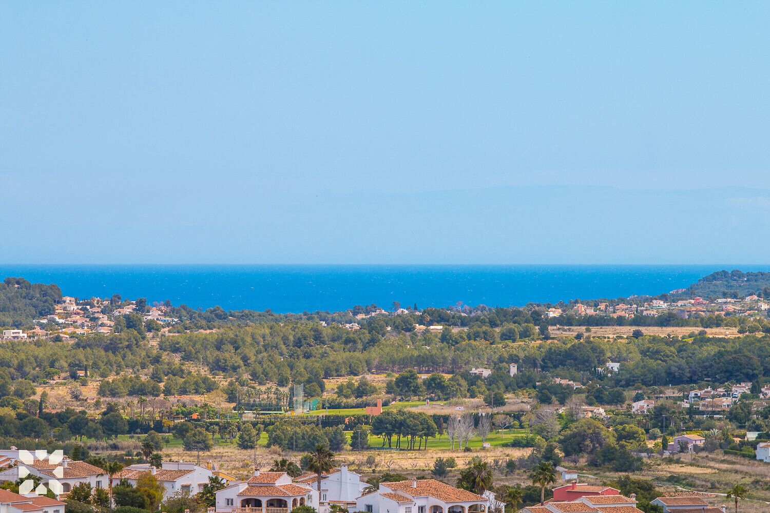 A coastal town with houses and a view of the sea.