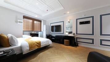 Ein Hotelzimmer mit Bett, Schreibtisch, Fernseher und Spiegel.