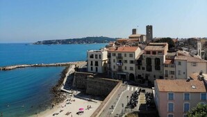 A coastal town with historic buildings, a beach, and a clear view of the sea. - Spacious new one-bedroom apartment in the heart of the Old Town (Antibes)