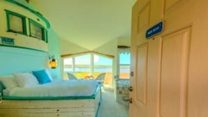A room with a bed, a window, and a door. - Panoramic views, 2-person soaking tub, Fireplace 2nd Floor (Moss Landing)