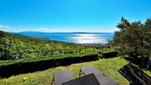A scenic view from a balcony overlooking a coastal landscape with a clear blue sky. - Holiday house Selak * large garden, terrace, sea view, free WiFi (Tucepi)