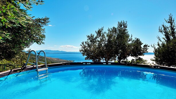 A clear blue swimming pool with a view of the sea and mountains in the background. - Holiday house Selak * large garden, terrace, sea view, free WiFi (Tucepi)