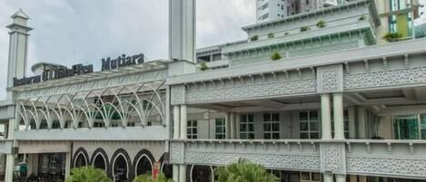 A hotel with a central courtyard, a fountain, and a sign reading "Hotel Mutiyana Penang".