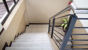 A staircase with a metal handrail and a potted plant on the right. - OYO 153 Espacio de Clarita Hometel (Davao)