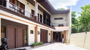 A modern building with a covered entrance, multiple doors, and a balcony. - OYO 153 Espacio de Clarita Hometel (Davao)