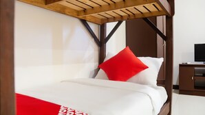 A bed with a wooden headboard, white bedding, and a red pillow. - OYO 153 Espacio de Clarita Hometel (Davao)