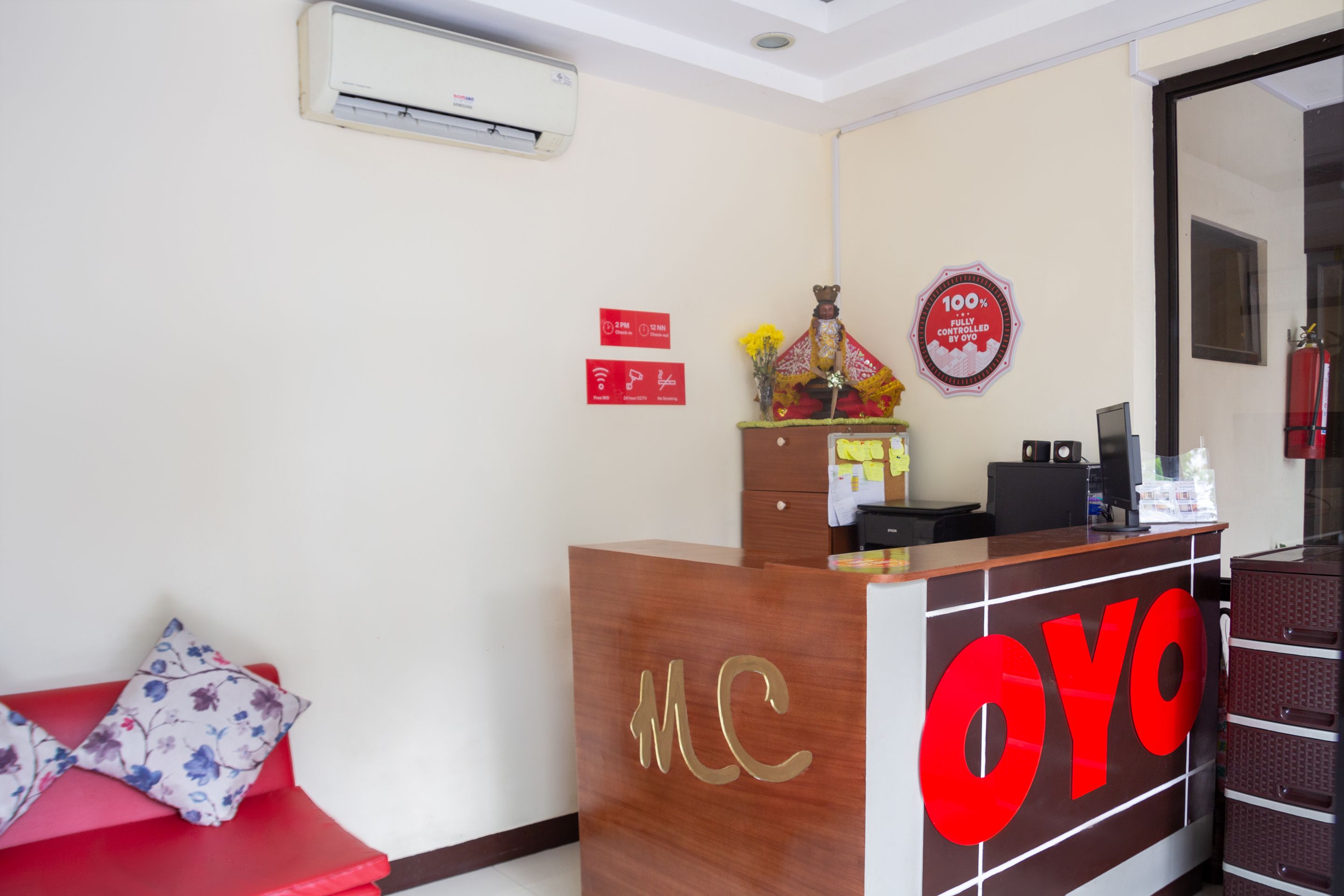 A reception desk with a wooden finish and the letters "MC" and "OYO" prominently displayed.