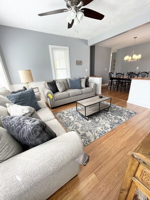 Relax in this stylish living room with a sofa, coffee table, and dining area.