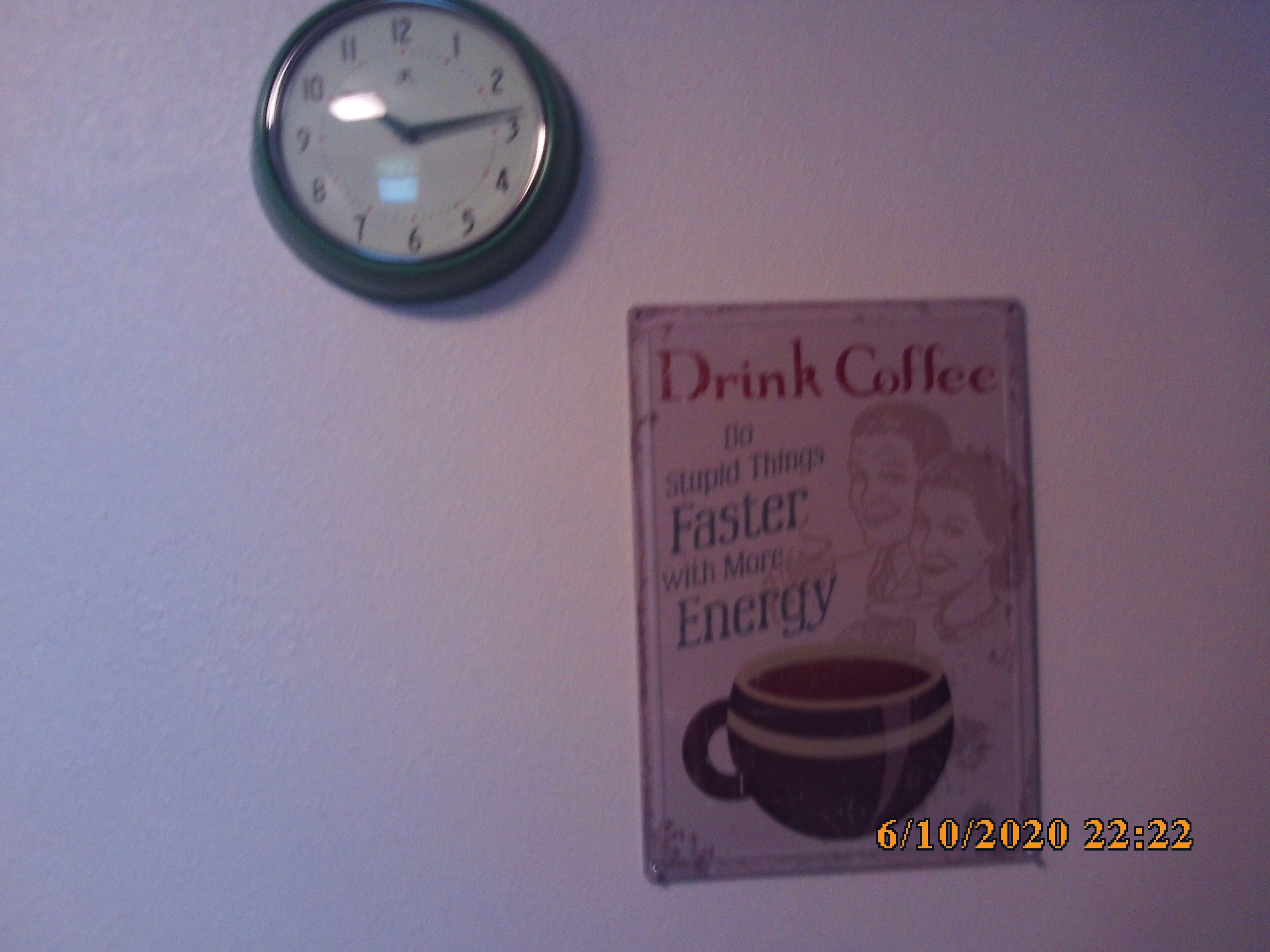 Une horloge murale et une affiche de motivation.